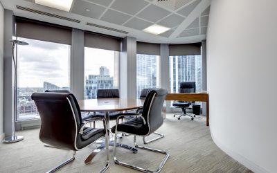 Small modern office boardroom and meeting room interior with desks, chairs and cityscape view